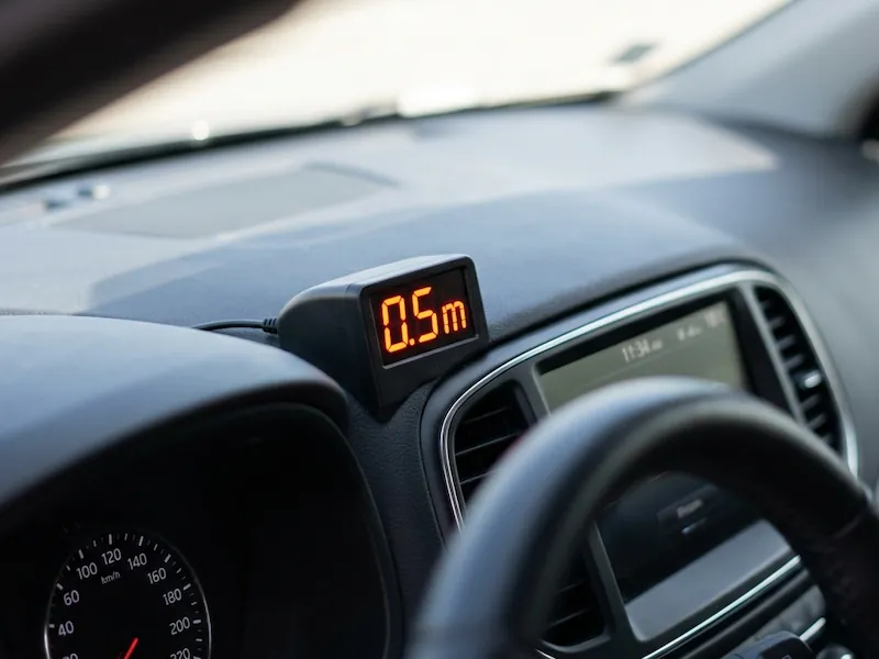  Afișaj digital pentru senzori de parcare montat pe bordul mașinii indicând distanța până la obstacol.